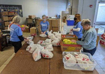 People around a table putting together food packages